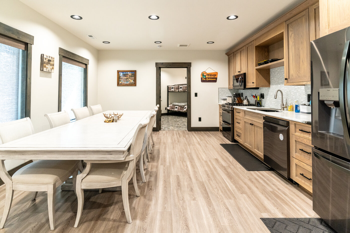 Beautiful Views — dining table with the kitchen behind it and a bedroom door beyond