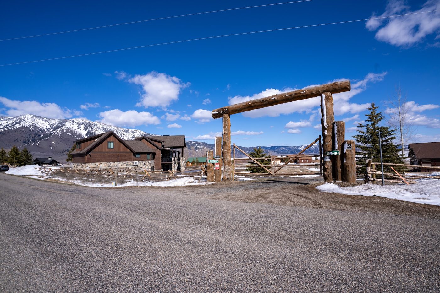 Beautiful Views — gated log-arch property entry with the lakefront cabin behind it