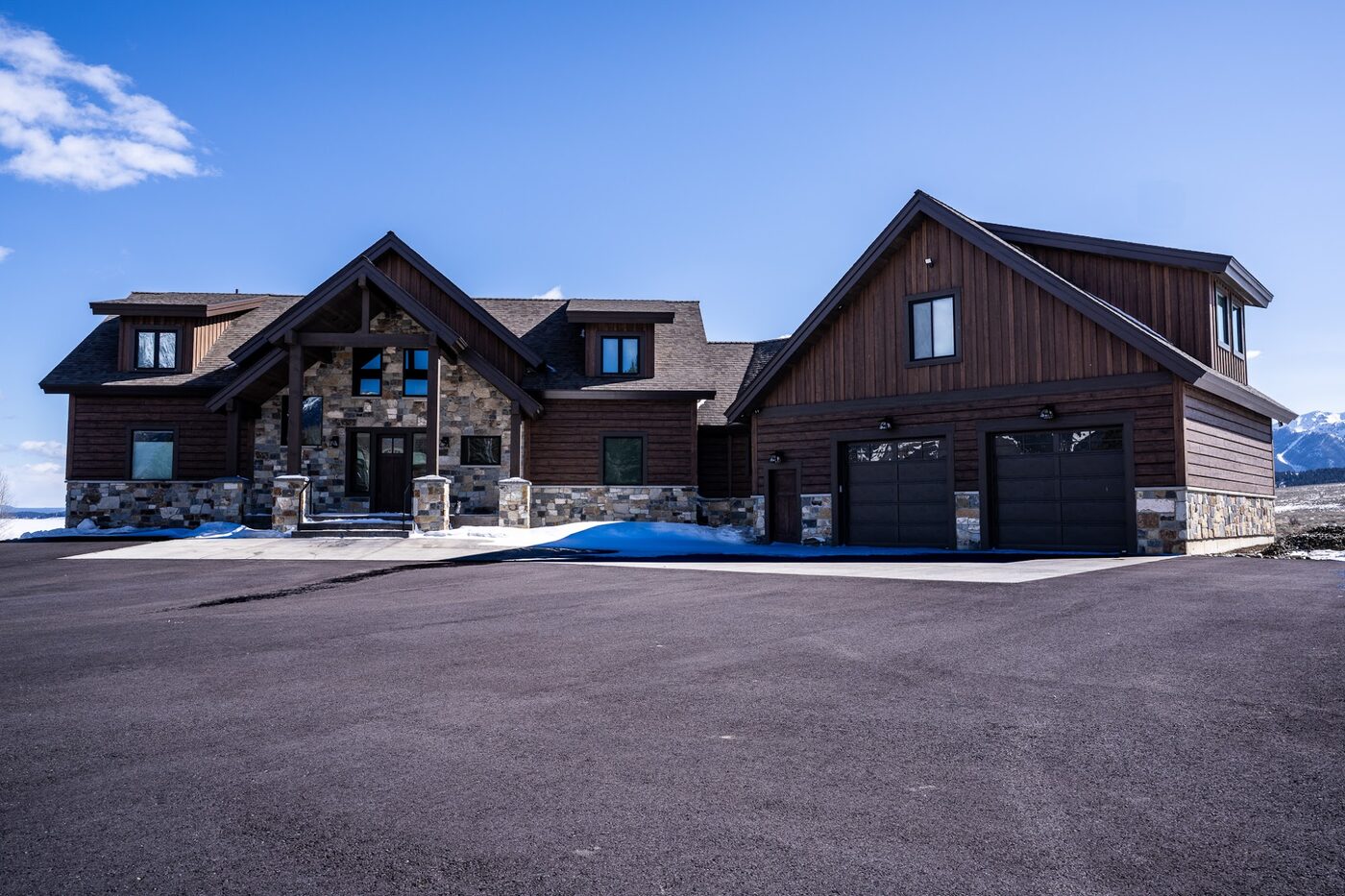 Beautiful Views — front exterior with three-car garage and Centennial Range in the distance