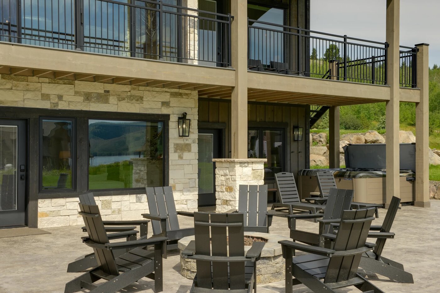 Lodge at Cutthroat Landing — lower patio fire pit ringed with Adirondack chairs and stone facade