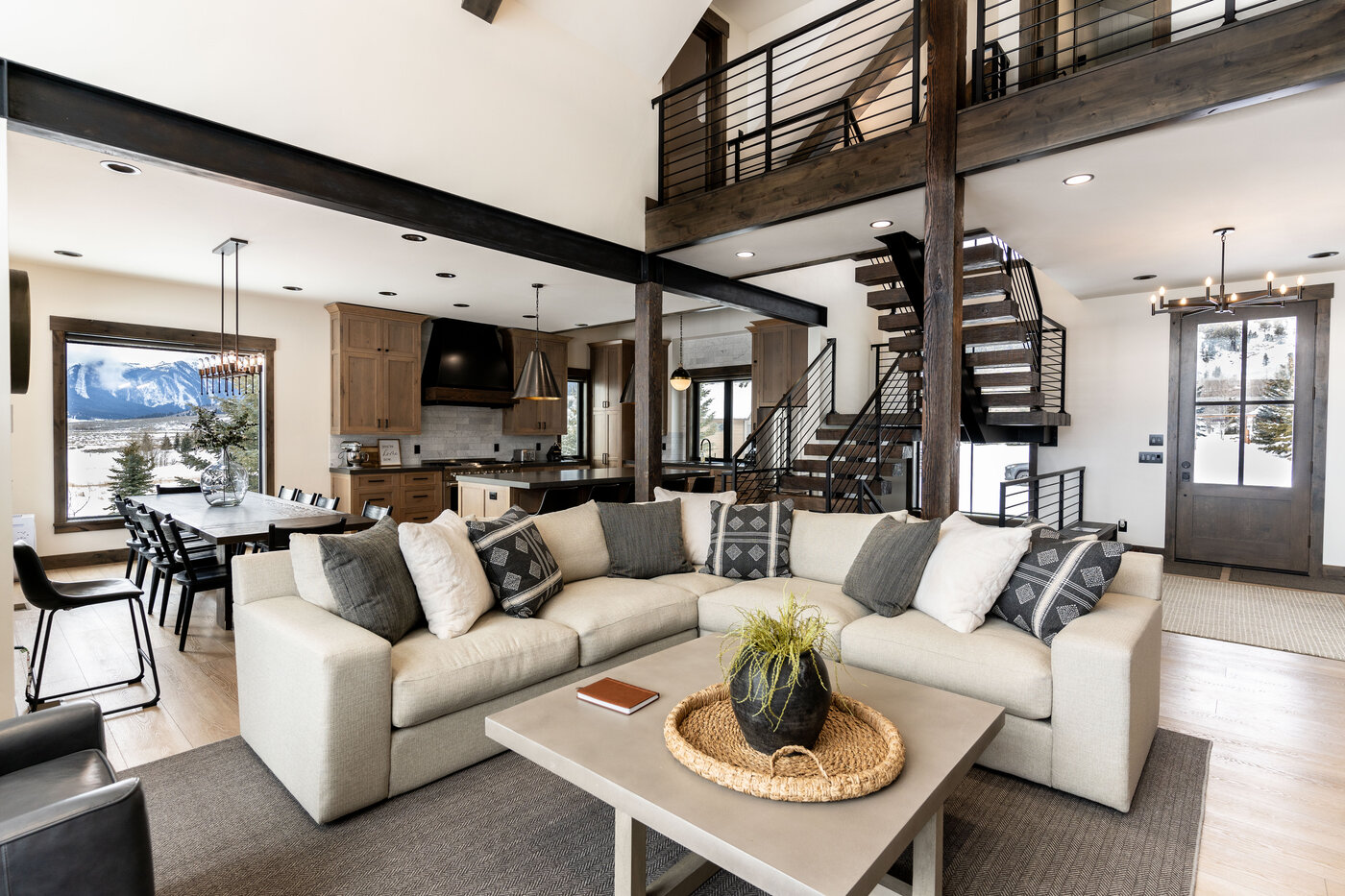 Lodge at Cutthroat Landing — open great room, dining table, and kitchen with mountain view through windows