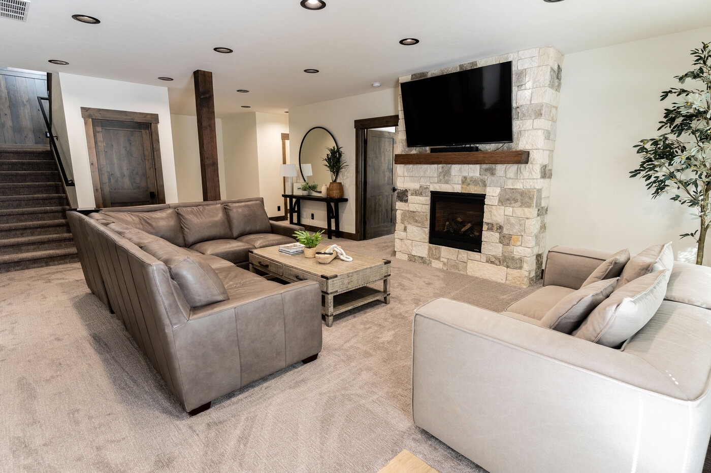 Lodge at Cutthroat Landing — secondary living area with leather couches and stone fireplace