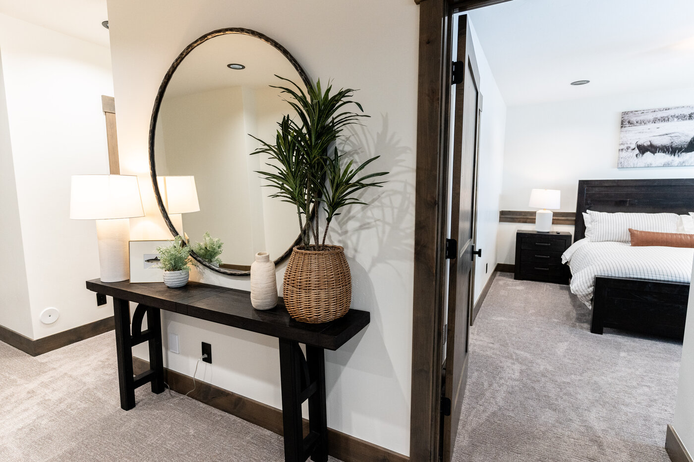 Lodge at Cutthroat Landing — upstairs entry with round mirror, console table, and bedroom beyond
