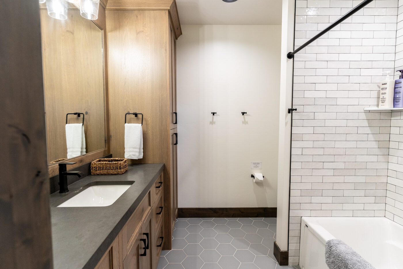 Lodge at Cutthroat Landing — bathroom with charcoal counter, oak vanity, and subway-tile shower