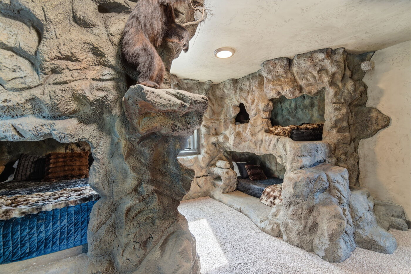 Riverfront Wildlife Lodge — bear-cave bedroom alcove beds tucked into the rock walls