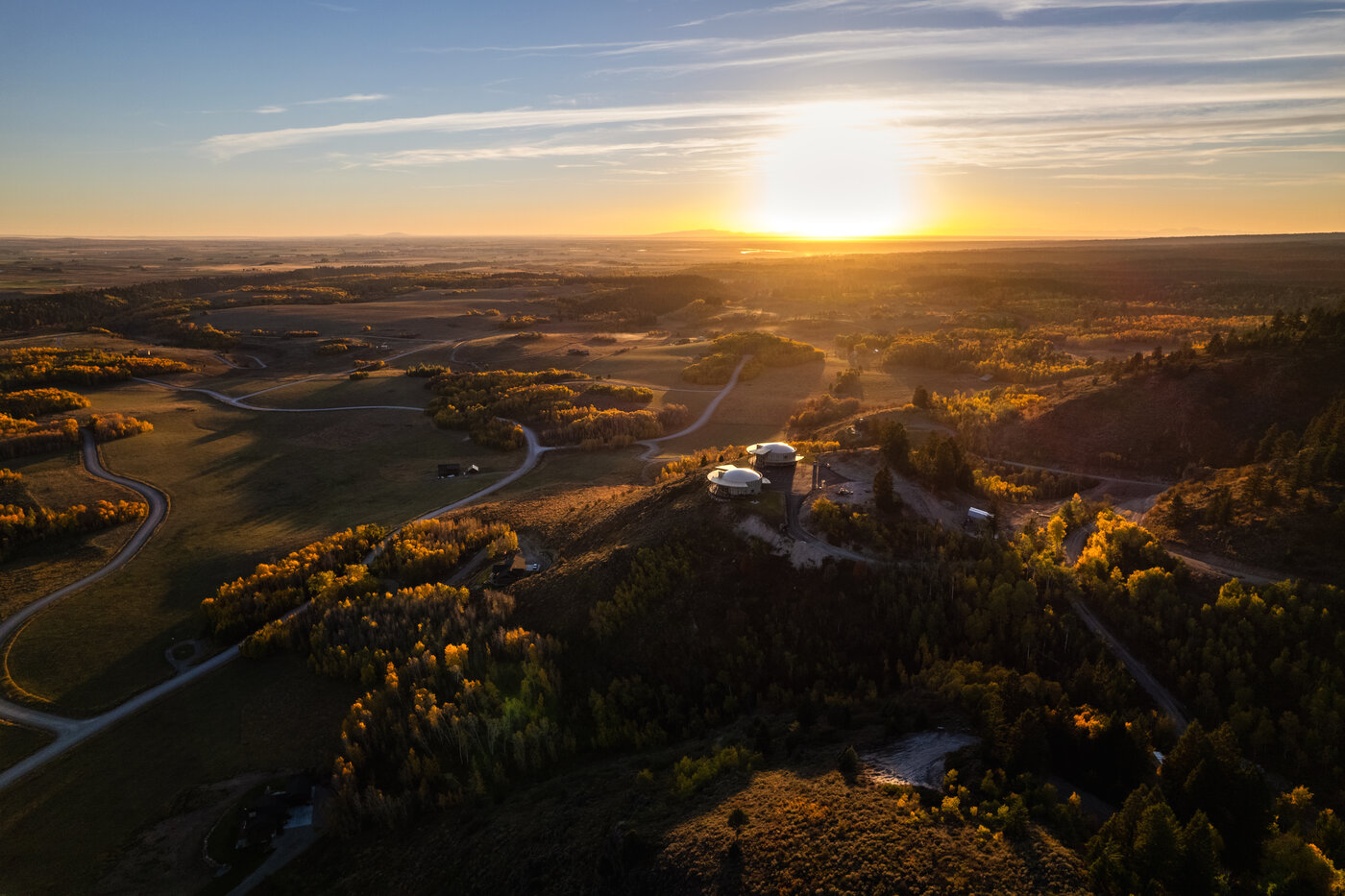 Teton View Retreat — West Cabin — aerial at golden hour with both domes on the ridge