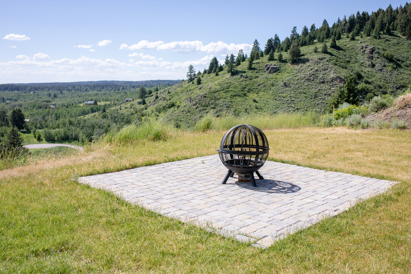 Teton View Retreat — West Cabin — sphere fire pit on a paver patio overlooking the valley