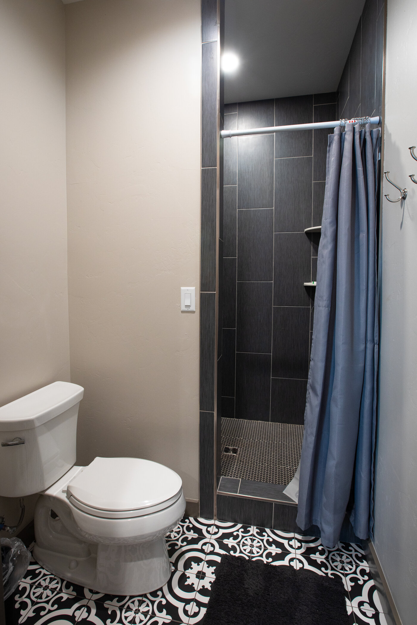 Teton View Retreat — West Cabin — secondary bathroom with charcoal tile shower and patterned cement floor