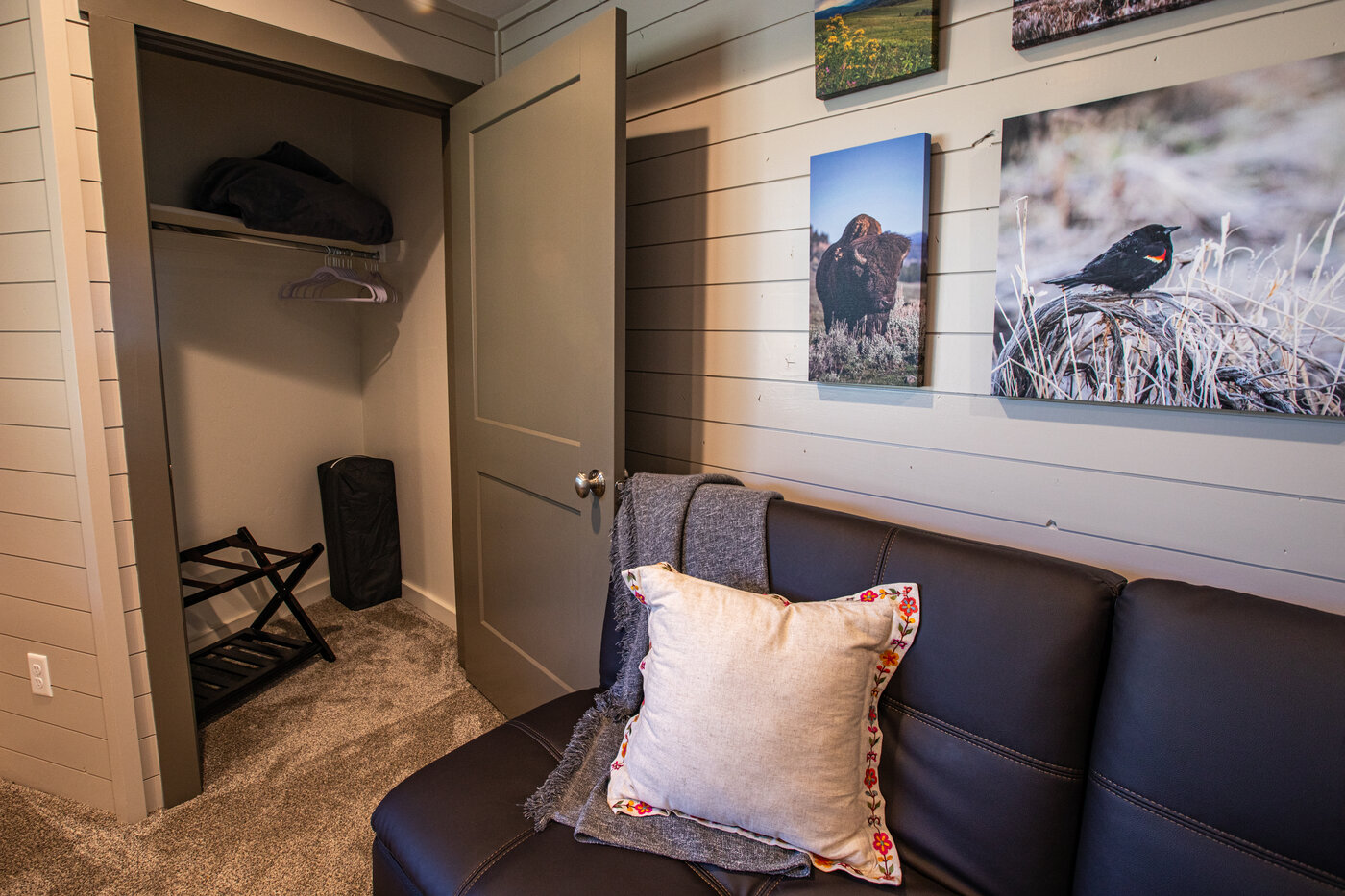 Teton View Retreat — West Cabin — bedroom seating area with leather couch and Yellowstone wildlife photography