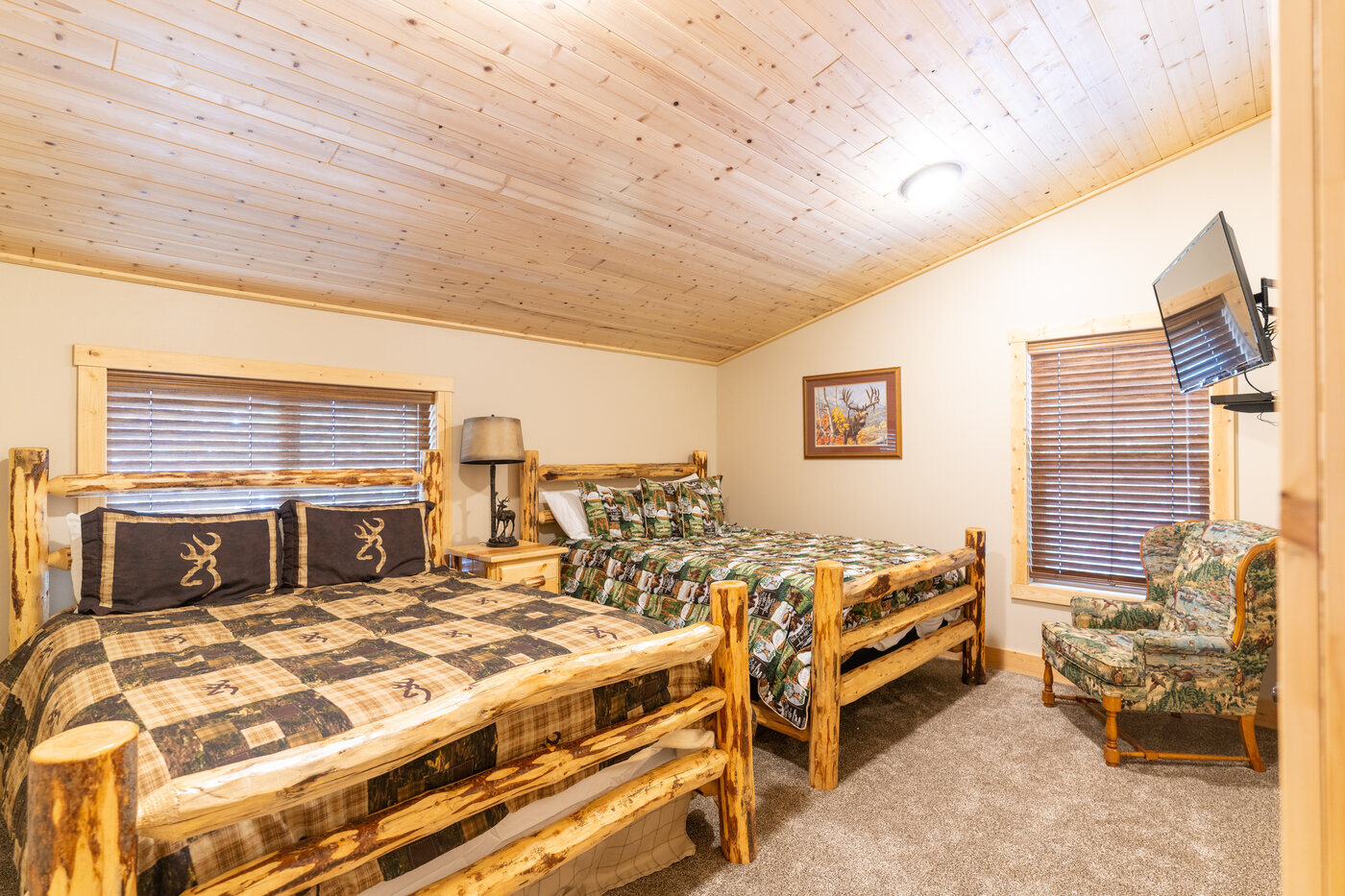 Trails End Lodge — kids' bedroom with two queen log beds, Browning logo bedding, and chair
