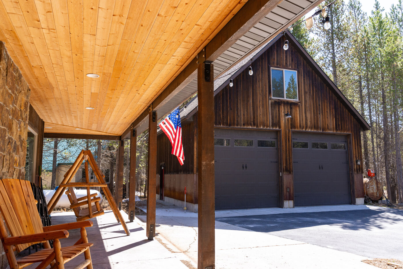 Trails End Lodge — detached two-bay garage with covered porch and US flag