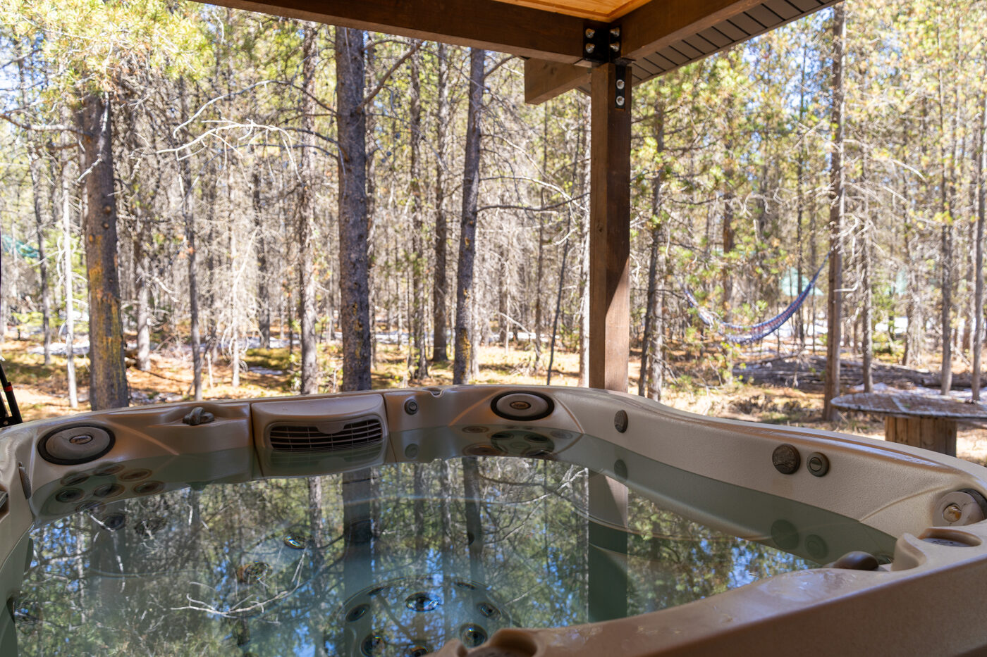 Trails End Lodge — covered-porch hot tub looking out into the lodgepole pines