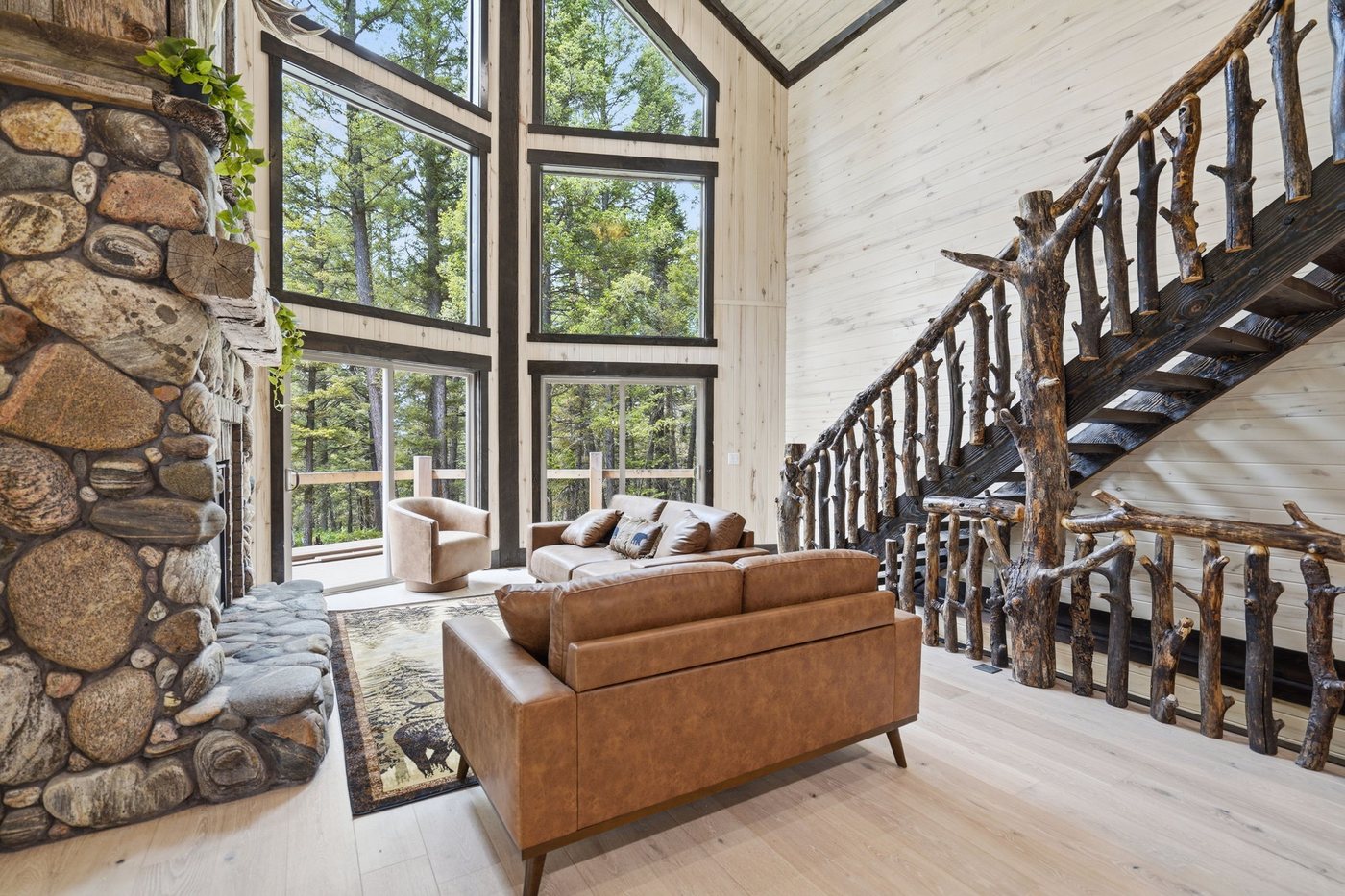 The Treehouse — great room with floor-to-ceiling stone fireplace and pine tree column