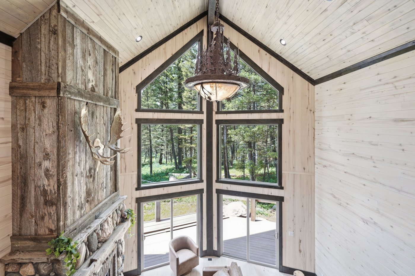The Treehouse — entry with tree branch stair railing and antler chandelier