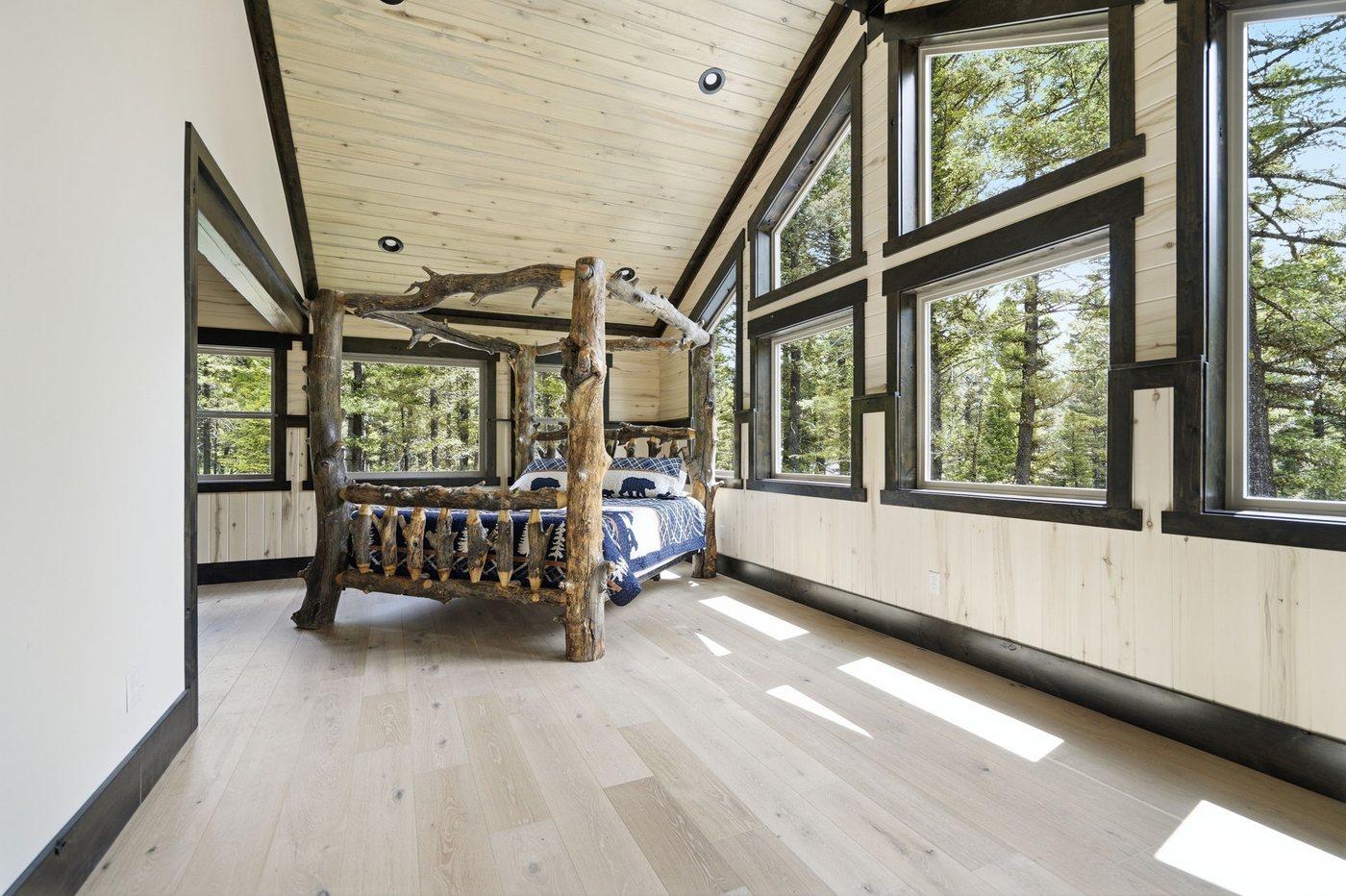 The Treehouse — bedroom with tree post bed and mountain bedding
