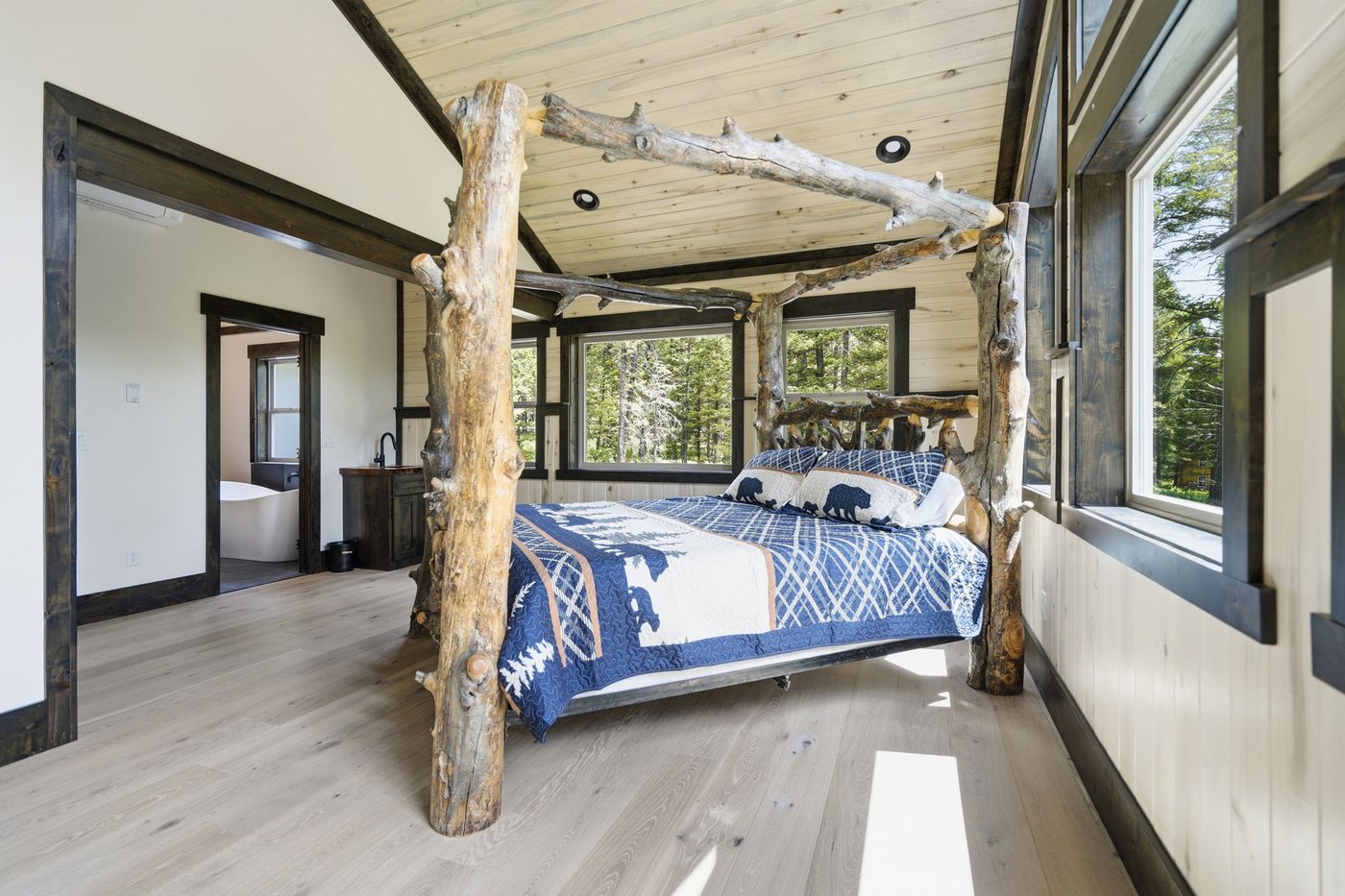 The Treehouse — bedroom with branch canopy and forest outlook