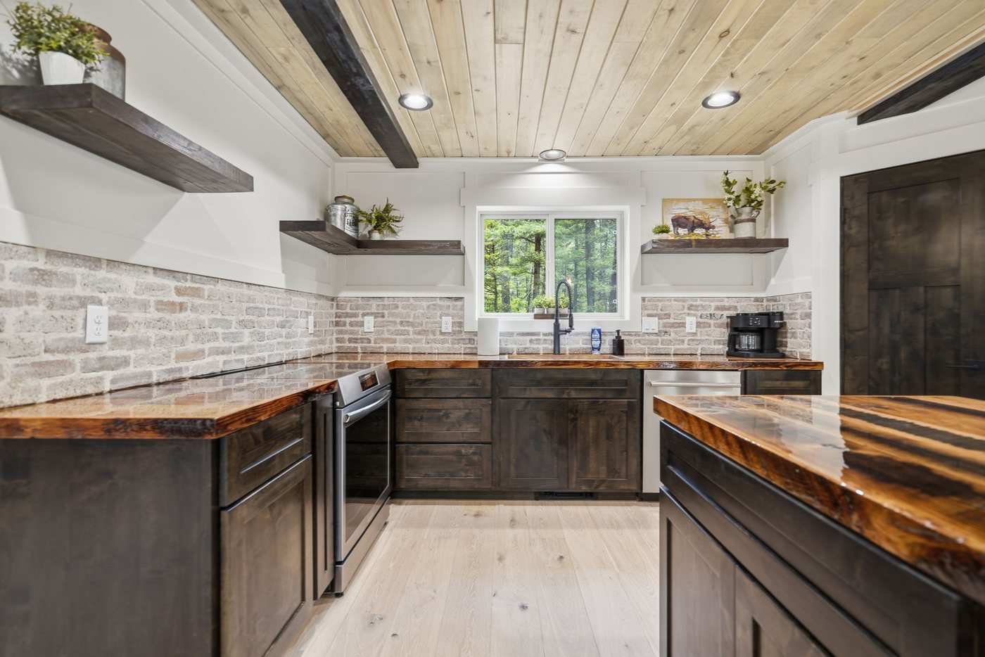 The Treehouse — kitchen with brick backsplash and dark cabinetry